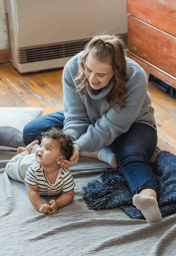 Parent playing with child on blanket